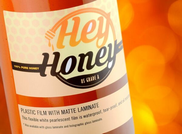 Custom honey label sample of Hey Honey artwork printed on plastic film label stock with matte laminate
