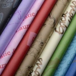 A colorful array of 10 stunning custom printed tissue paper folded sheets in a row