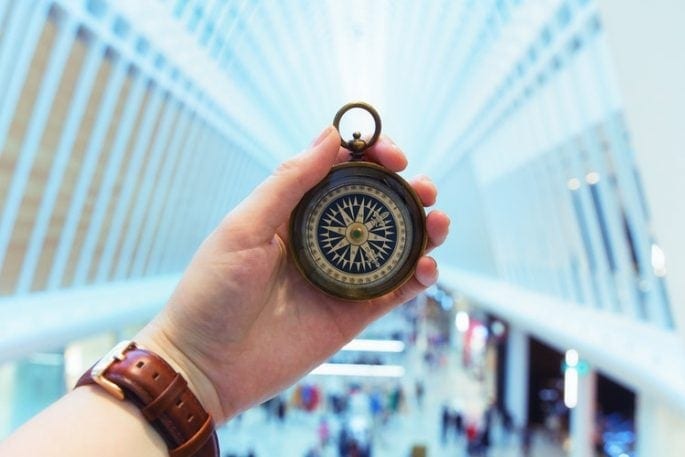 Person holding compass in shopping mall