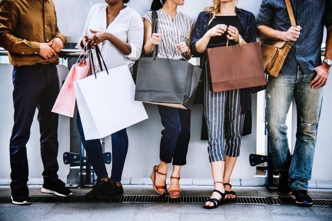 How to Label Your Products for Market Success - Shoppers in line with shopping bags