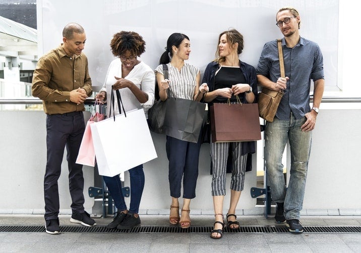 Female and male shoppers standing in one line chatting with each other