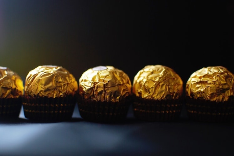 Shiny gold foil on Ferrero Rocher makes chocolate look like treasures to covet