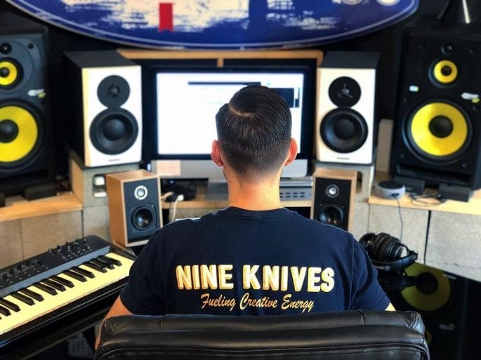 Nine Knives - Shaun in Studio - Raw Tech Studios - Wearing Nine Knives Shirt Back View - Inkable Label Co. Spotlight